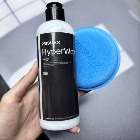 Liquid wax from Prismax HyperWax Car Care Products, featuring a clear bottle with a blue cap and liquid wax inside
