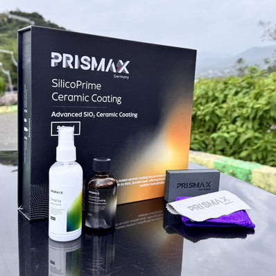 Close-up of Prismax SilicoPrime Ceramic Coating bottle with application sponge on a shiny car surface.