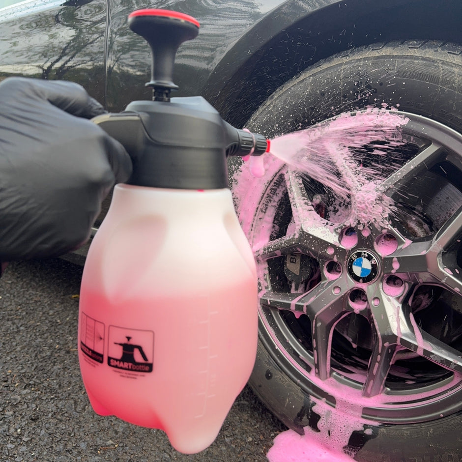 Prismax Foam Meister foam cannon attached to a garden hose, used for car washing with thick foam cleaning solution.