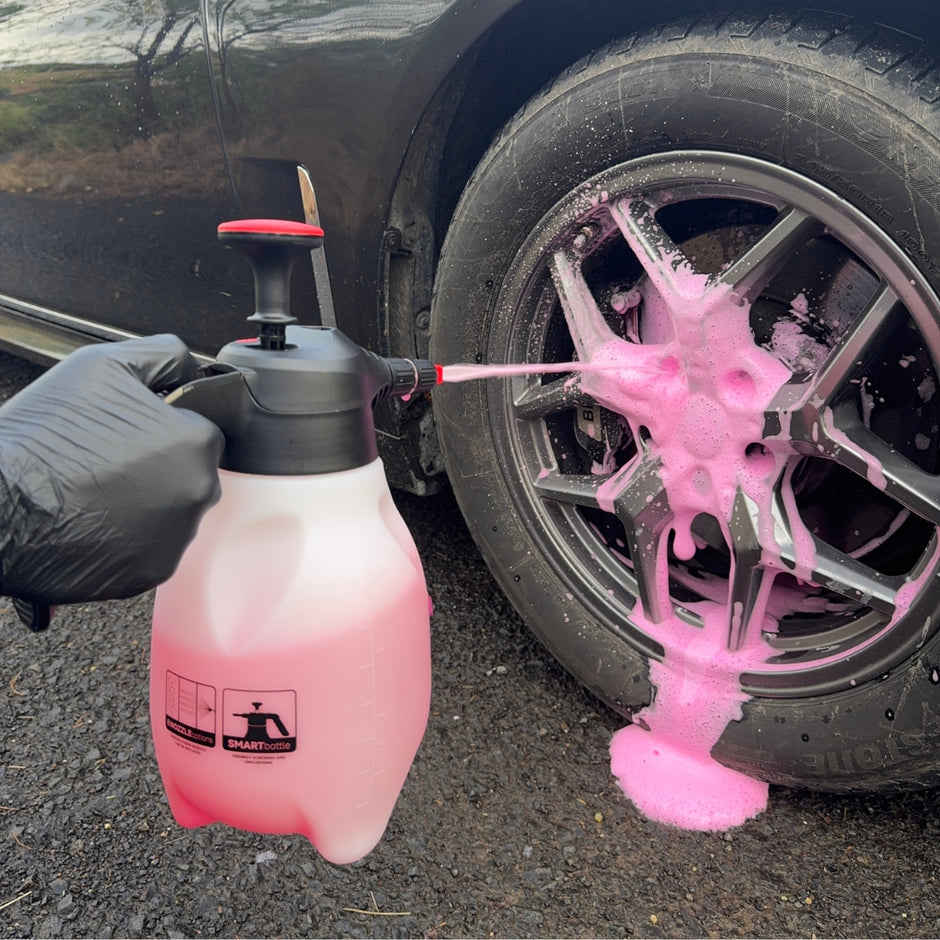 Prismax Foam Meister foam cannon attached to a garden hose, showing a wide spray of thick foam for car washing.